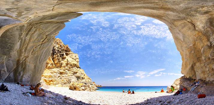 A cave with a beach and blue water

AI-generated content may be incorrect.